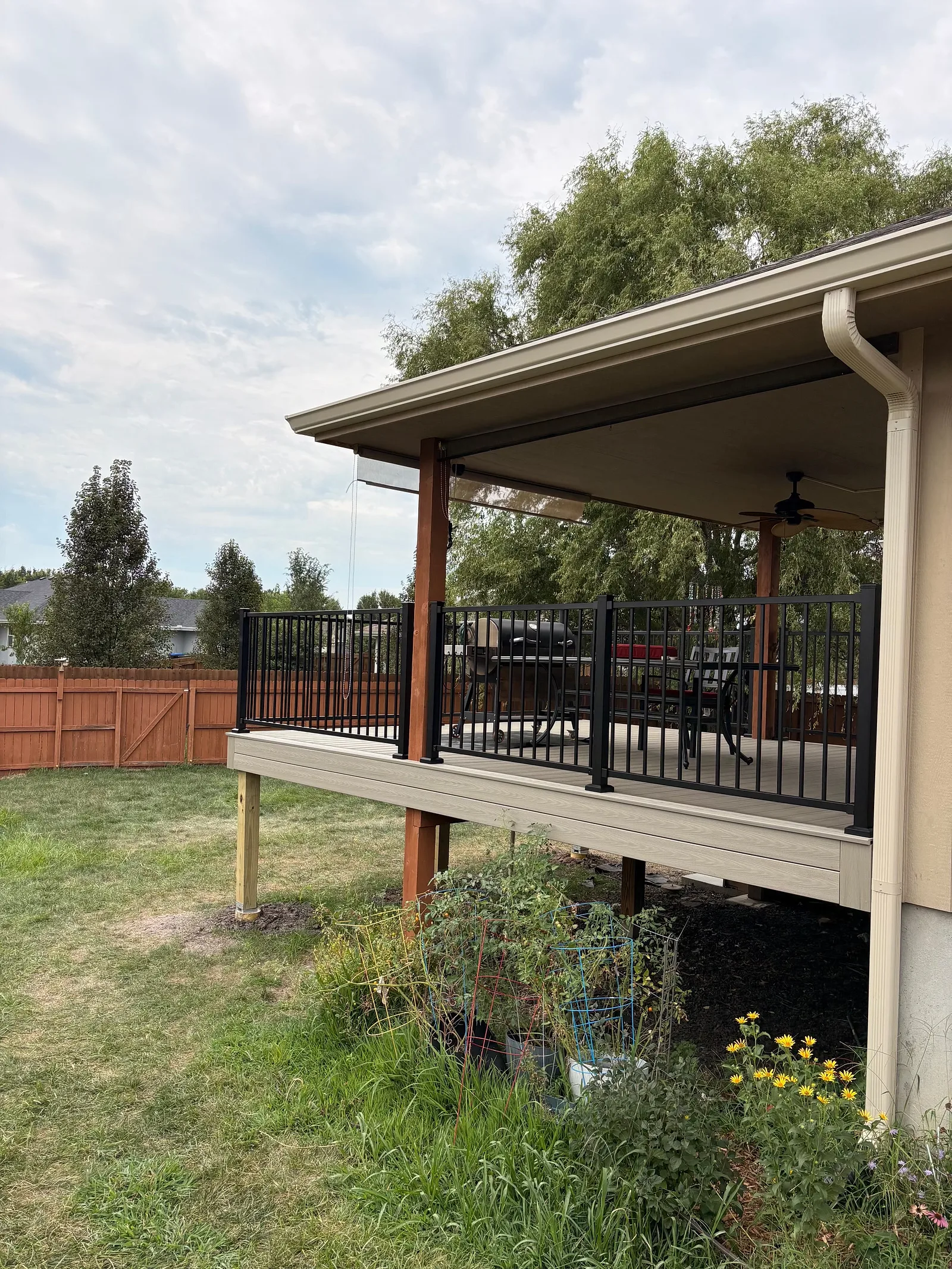 Elevated deck posts on concrete footings with black metal railing in a Topeka, KS backyard
